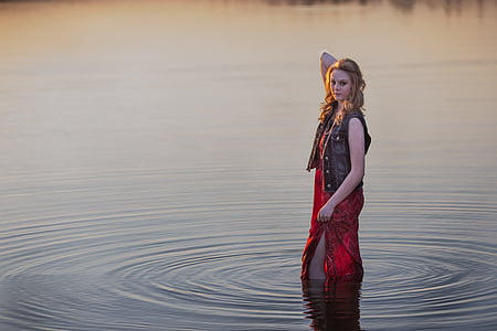 standing woman in water wearing red dress