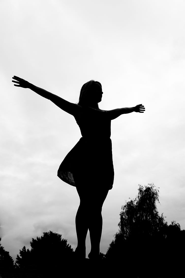 silhouette photo of woman with arms wide open