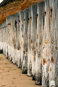brown handprints on gray wooden logs