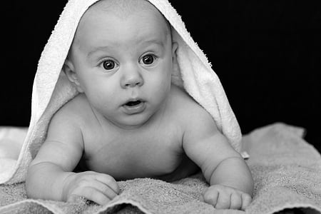 grayscale photo of a baby with white textile on top