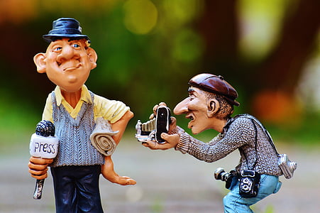 two male camera man and newscaster figurines