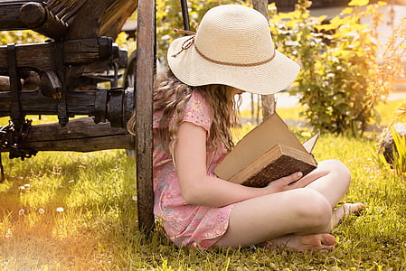 girl reading book on the grass