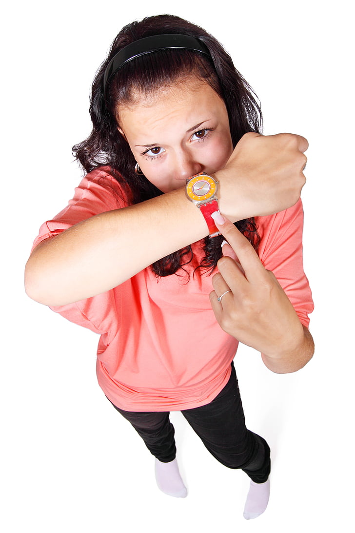 woman wearing pink top and pointing her watch