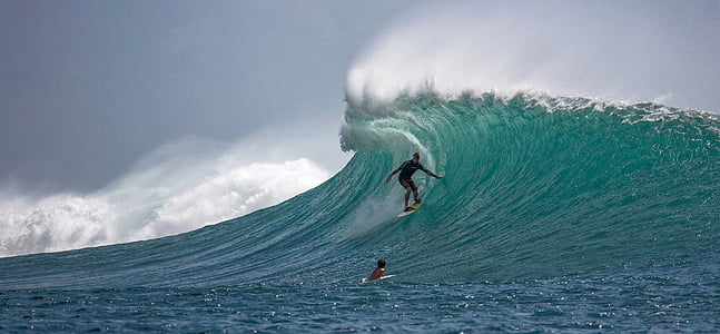 portrait photography of person surfing on wave barrels