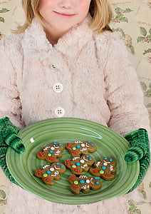 girl holding green plate with gingerbreads
