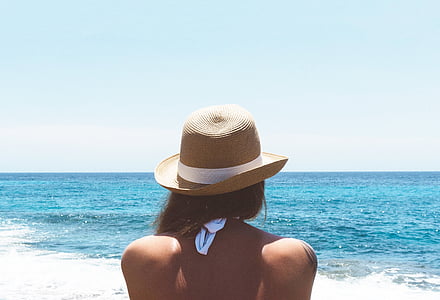 woman wearing brown straw hat at the beach