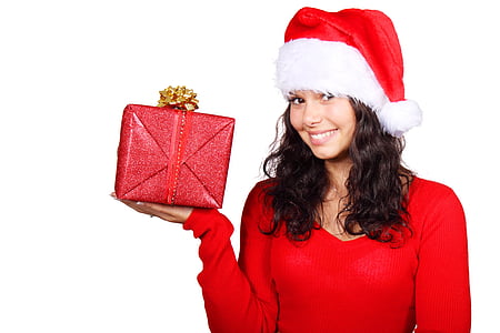 woman wearing Santa hat while holding red gift