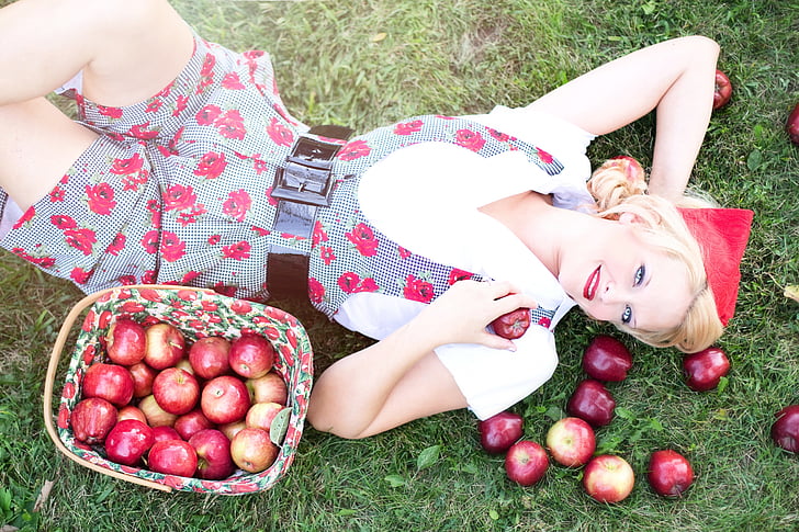 woman lying down with bunch of apples