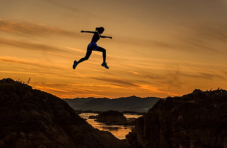 silhouette of woman jump on the rock