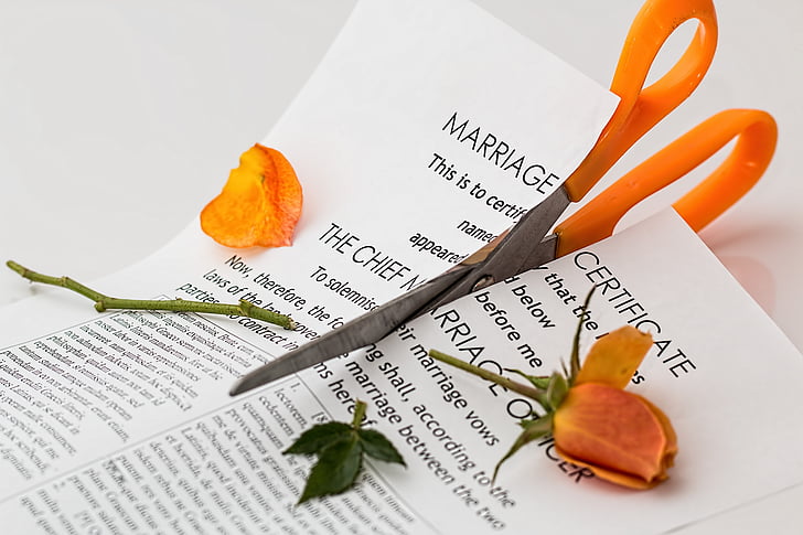 orange scissors cutting marriage certificate