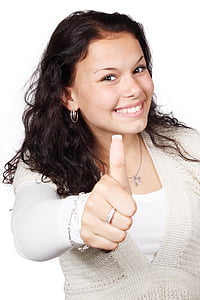 woman in white shirt doing thumbs up hand gesture