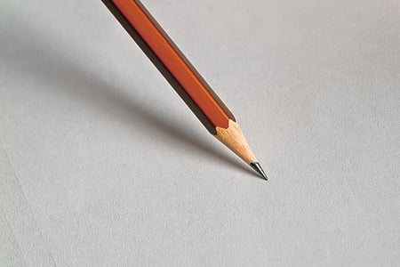 macro photography of brown pencil tip on white surface