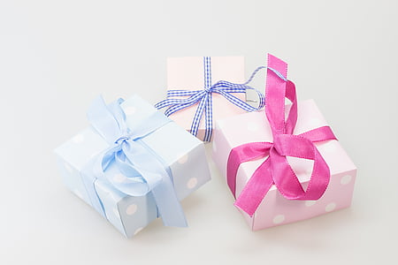 three assorted-color wrapped gifts on white surface