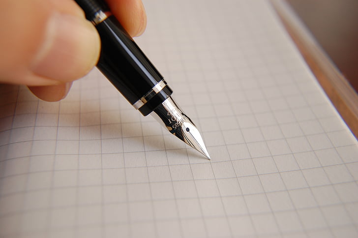 person holding black and grey fountain pen