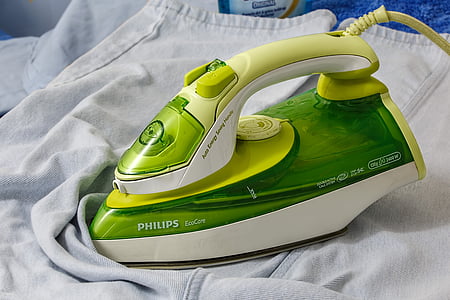 green and white Philips EcoCare clothes iron on white textile