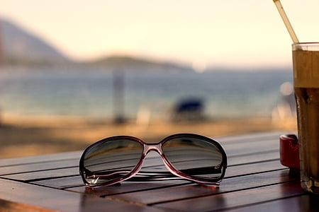 selective focus photography of aviator-style sunglasses on wooden table