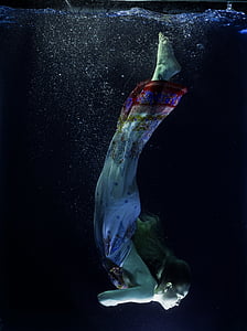 woman in white, red, and blue dress diving on water