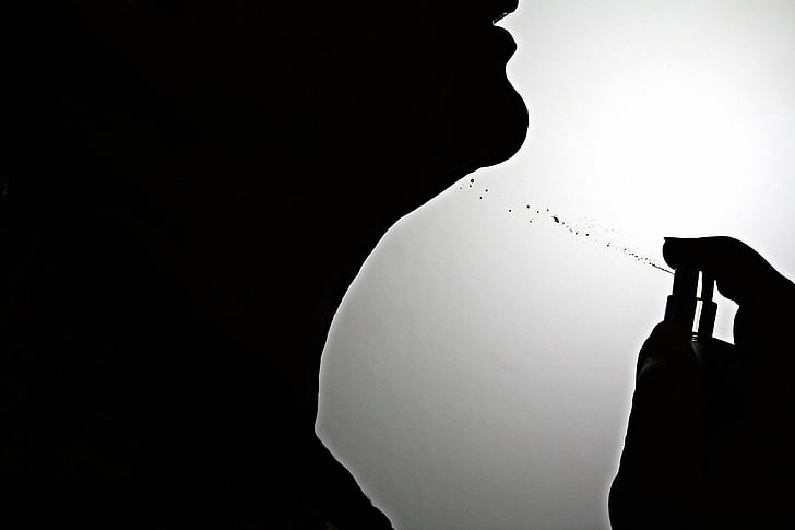 silhouette of person using spray bottle