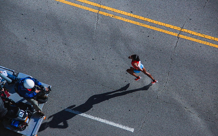 person running on gray concrete road taken during daytime