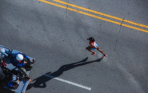 person running on gray concrete road taken during daytime
