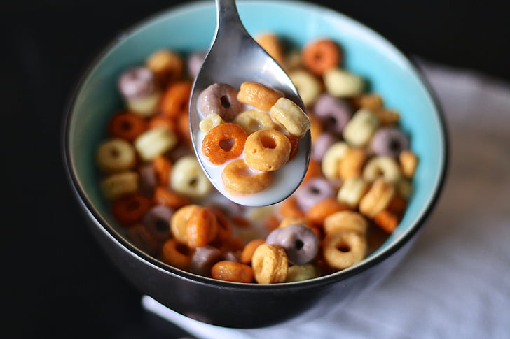 multicolored cereal with milk place on round black ceramic bowl