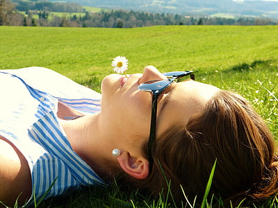 woman wearing sunglasses lying on grass