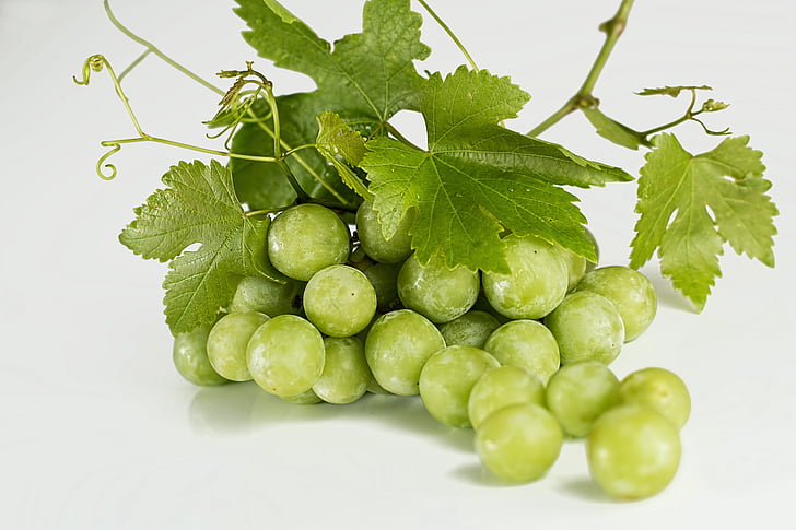 green grapes on white table top