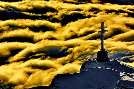 cross statue on top of white mountain during day time
