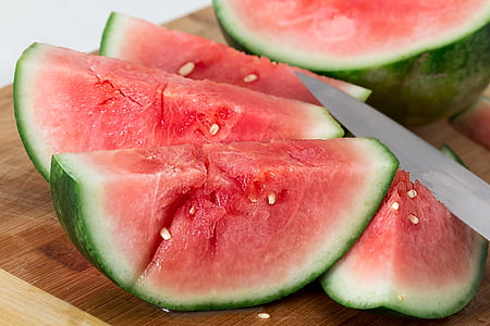 sliced water melon on brown wooden chopping board