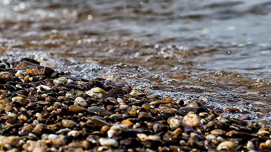 photo of stone pebbles at seashore during daytime