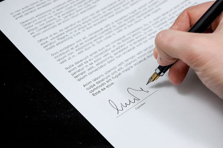 person holding signature pen