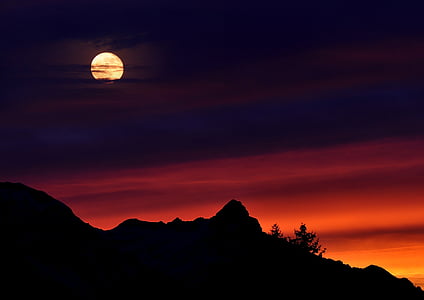 new moon over silhouette of mountain