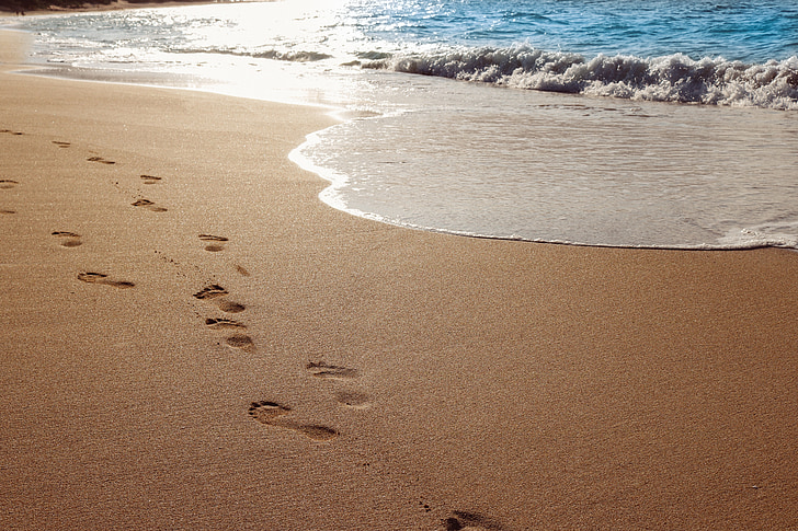 footsteps on sand near shore