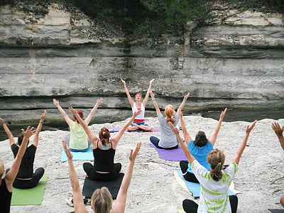 women doing yoga on rock formation