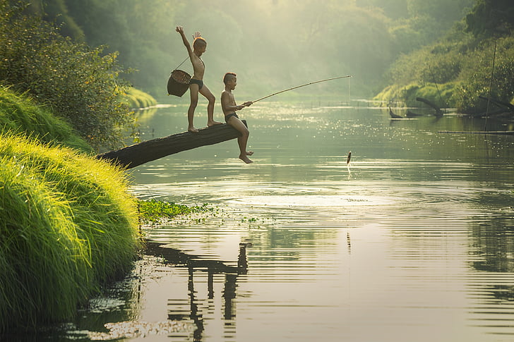 two boys fishing in a river