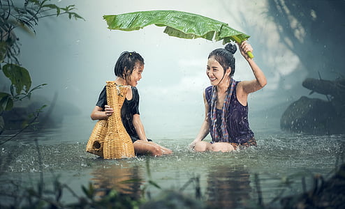 two women playing under the rain