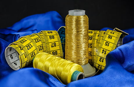 depth of field gold-colored and yellow threads beside tape measure