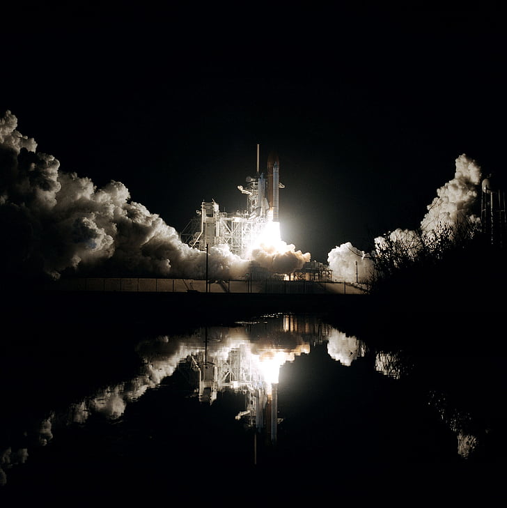 photo of white shuttle launching at nighttime