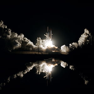 photo of white shuttle launching at nighttime