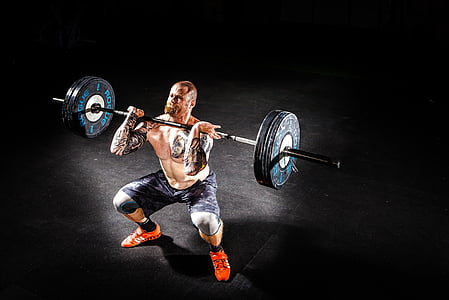 man wearing a black short while lifting a black steel barbell