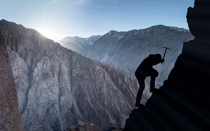 person climbing on mountain silhouette photo