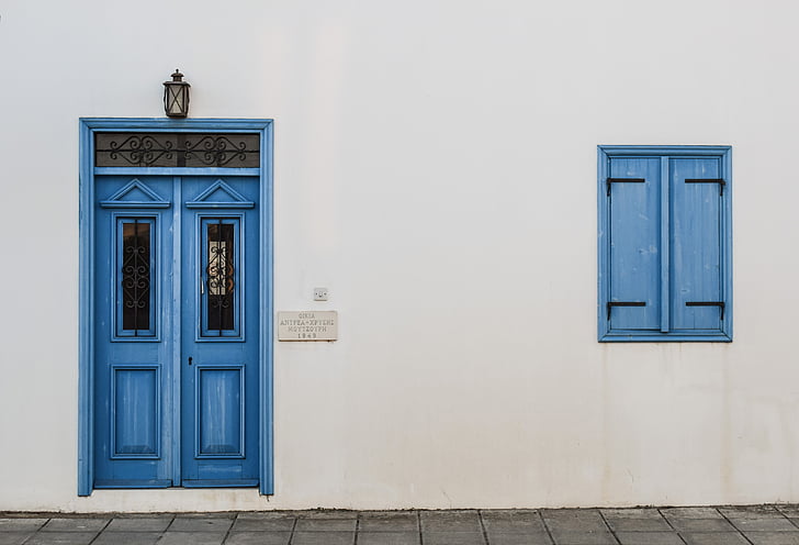 white concrete wall with blue door and window