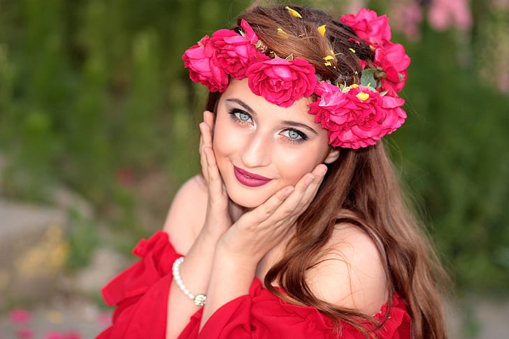 woman wears red off-shoulder shirt with red flower headdress