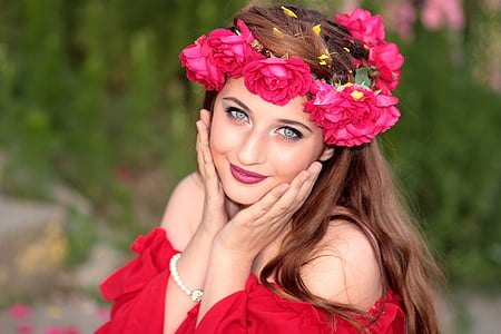 woman wears red off-shoulder shirt with red flower headdress