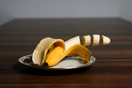 ripe banana on white ceramic saucer