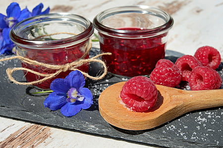 raspberry on ladle near glass bowl