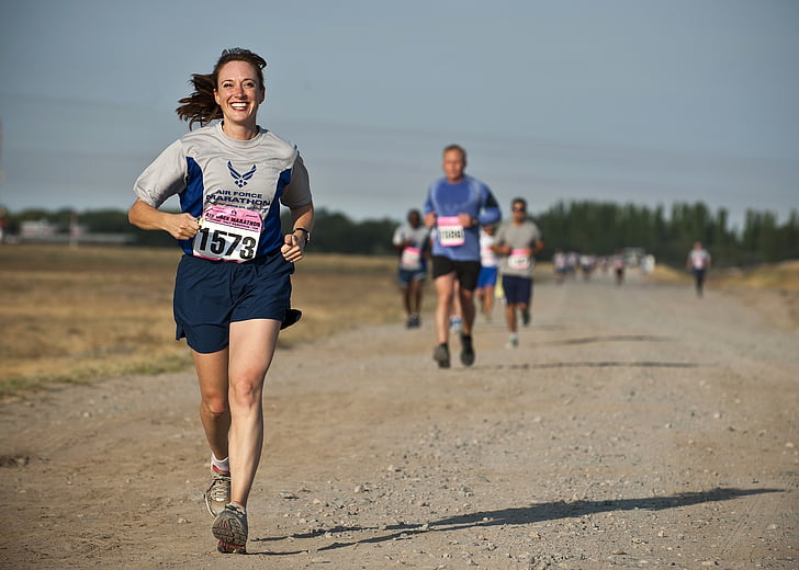woman in grey shirt running on marathon