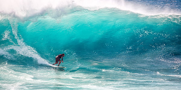 man in black long-sleeved shirt surfing on high ocean waves