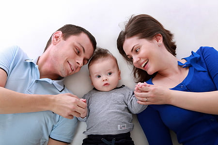 baby between man and woman holding their hands