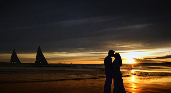 silhouette couple kissing near beach